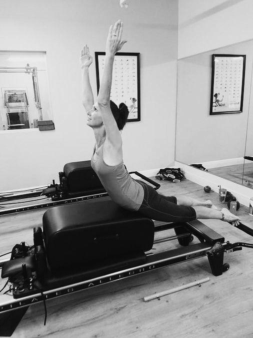 Instructor coaching a client on the reformer