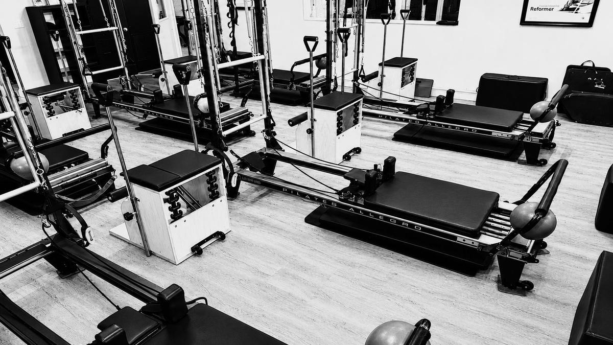 The Pilates On Fifth group class room with reformers and towers